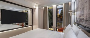 A hotel room with a large bed, a flat-screen TV, a small table, and a view of a building with a tower. - The Ritus Hotel Istanbul Sultanahmet, Tapestry Collection by Hilton (Istanbul)