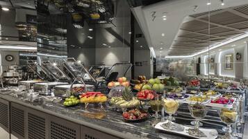 A buffet with a variety of fruits and vegetables, a glass display case, and a modern interior design.