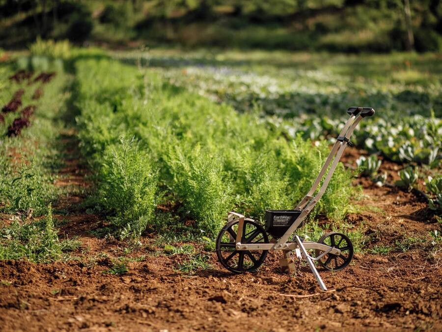 A garden with a wheelbarrow and a small black container labeled 'EarthMap.'