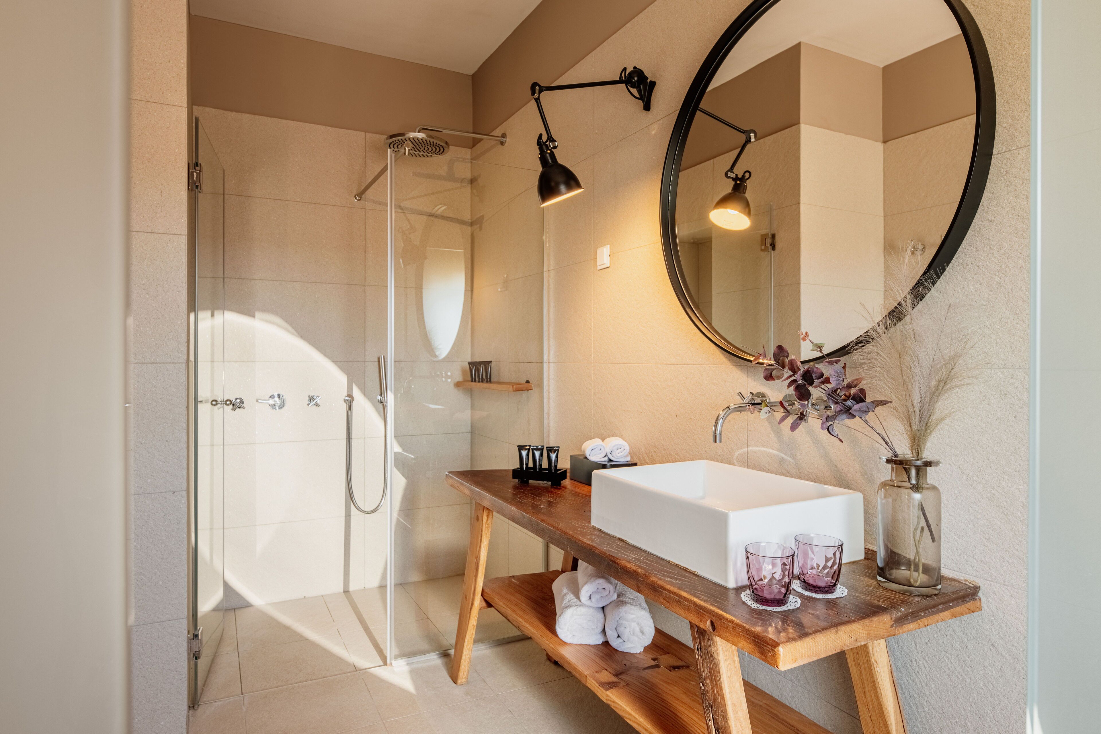 Une salle de bain moderne avec une douche à parois de verre, un meuble-lavabo en bois avec un vasque blanche et un grand miroir.