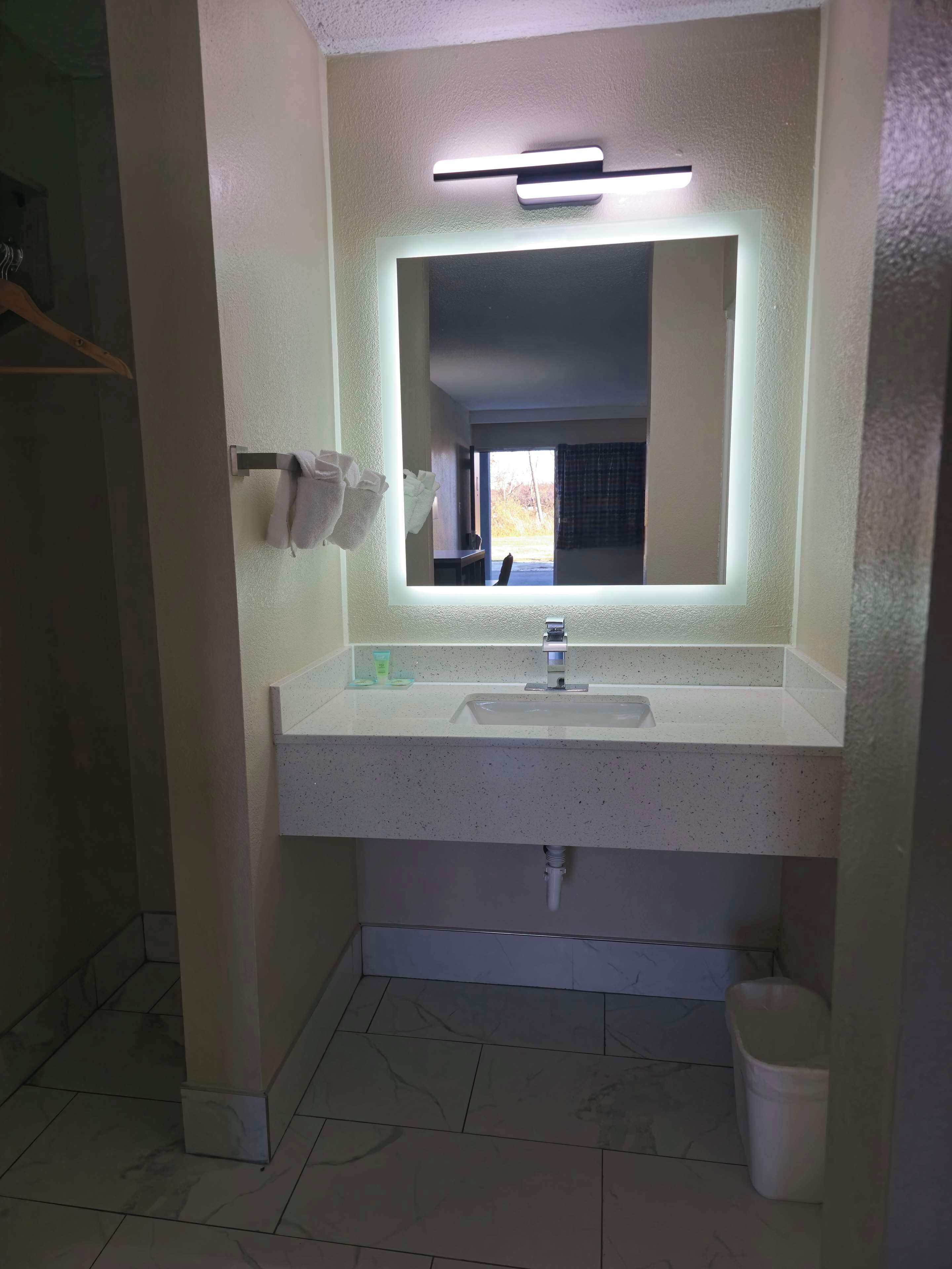 Une salle de bain avec un lavabo blanc, un miroir et un porte-serviettes.