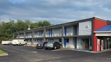 A motel with multiple rooms, a parking lot, and a visible Pepsi vending machine.
