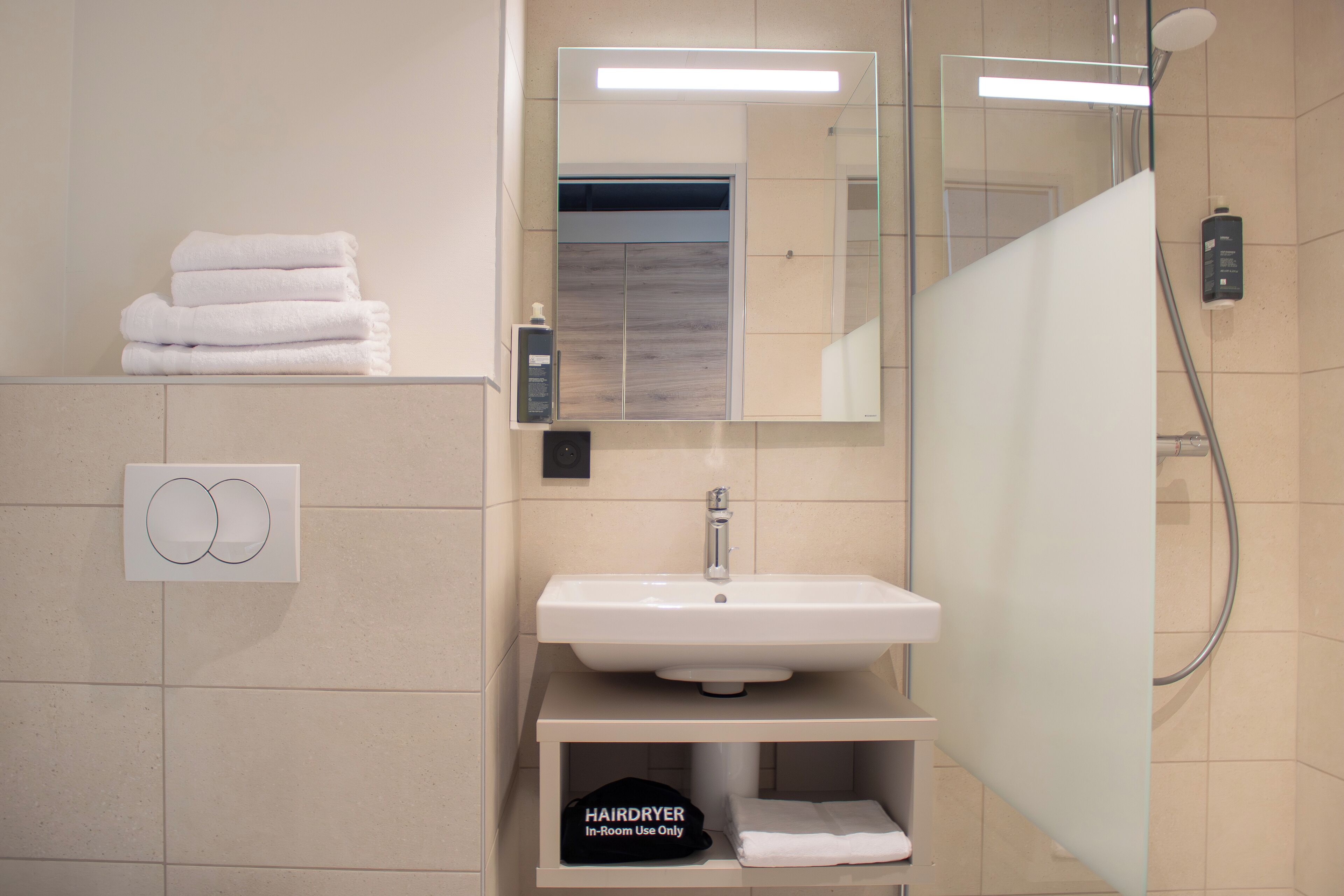 Ein modernes Badezimmer mit Waschbecken, Spiegel und Handtuchhalter.
