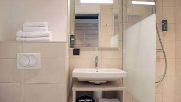 Ein modernes Badezimmer mit Waschbecken, Spiegel und Handtuchhalter.