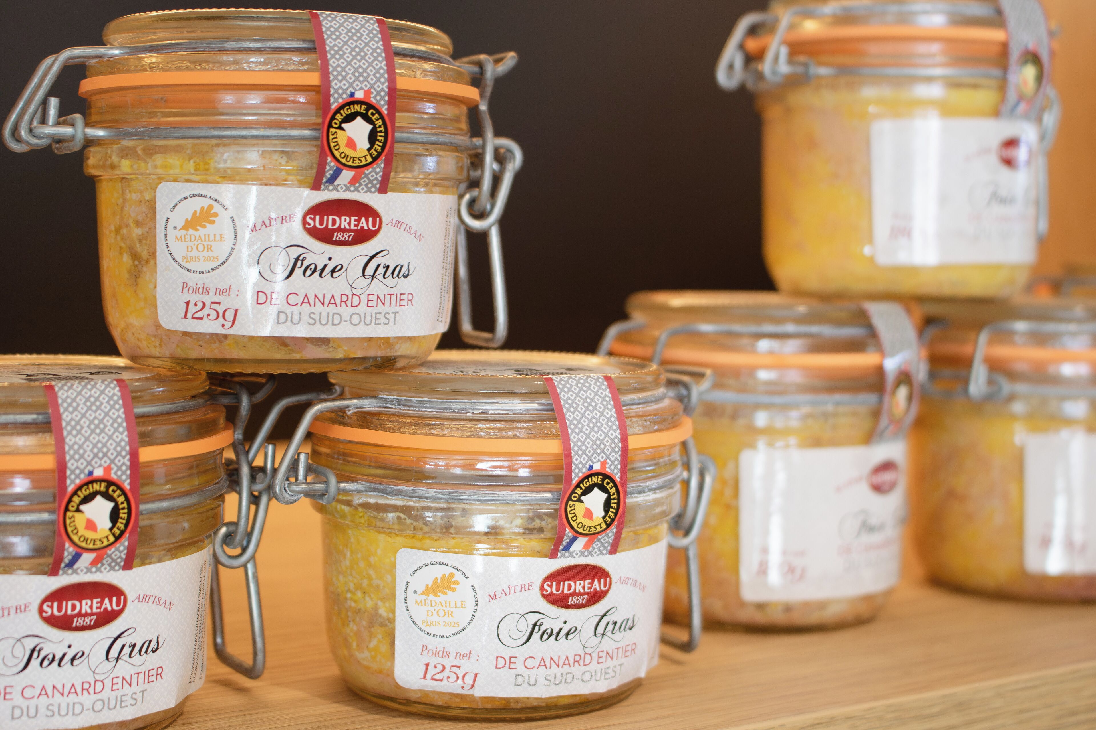 Multiple glass jars with metal clasps, each labeled 'Foie Gras de Canard Entier du Sud-Ouest' and weighing 125g.