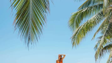 位於海灘上、遮陽傘、海灘浴巾、風浪板