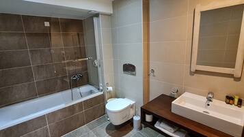 A modern bathroom with a bathtub, toilet, and sink.