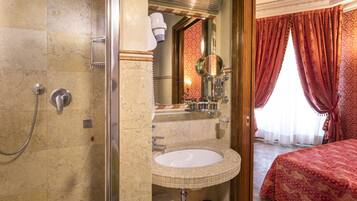 Un baño con ducha, lavabo y espejo.