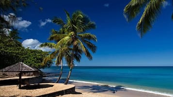 On the beach, white sand, sun-loungers, beach towels