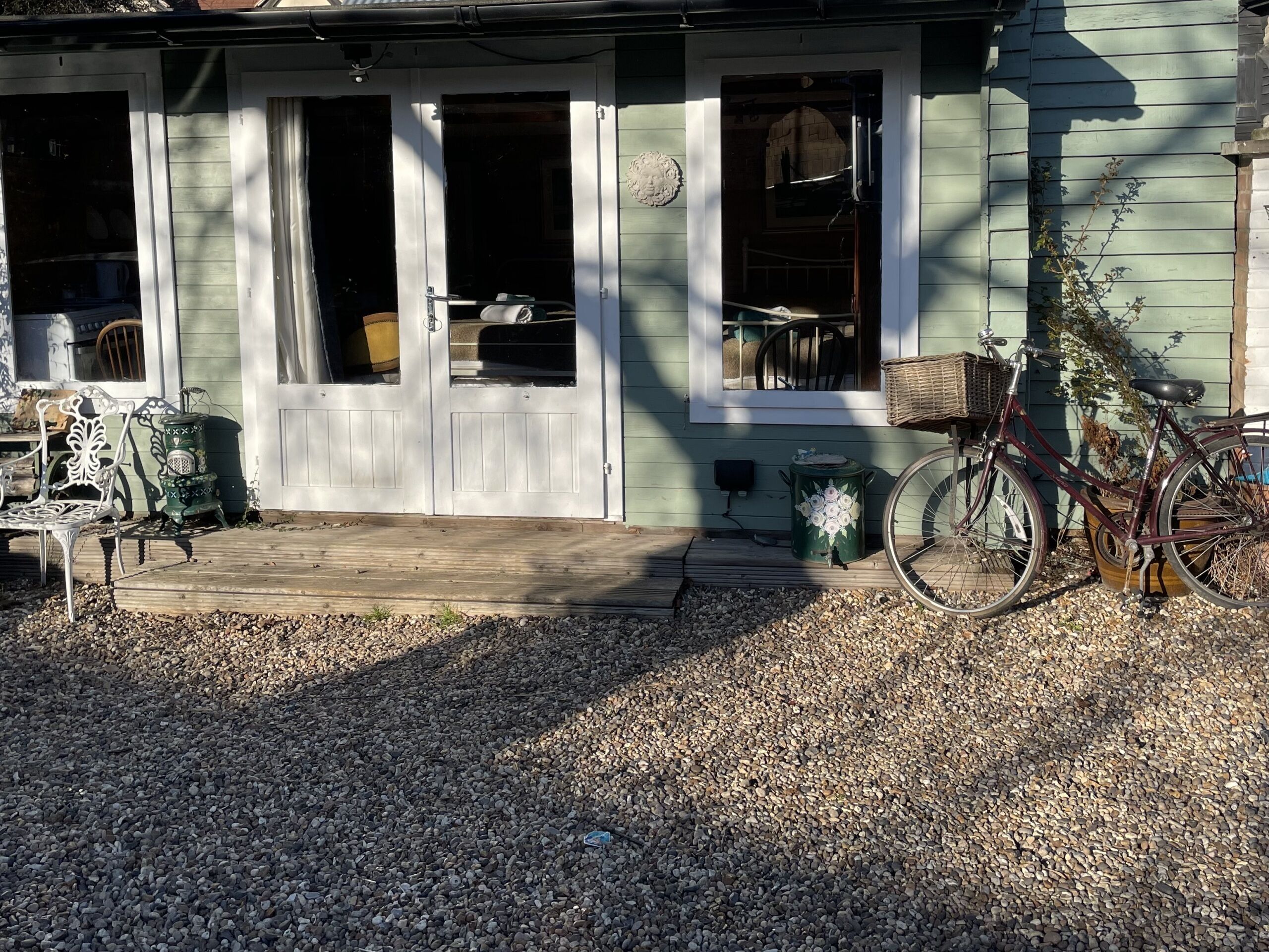 A house with a porch, a bicycle, and a bench.