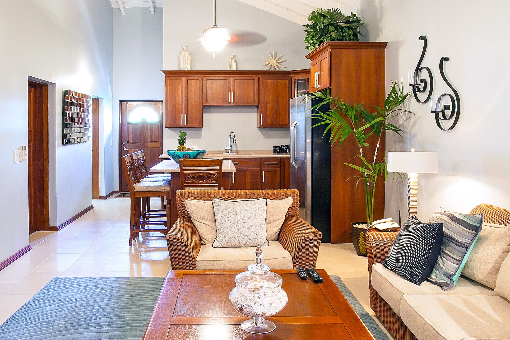 Una cocina moderna con armarios de madera, un refrigerador y un comedor con mesa y sillas.