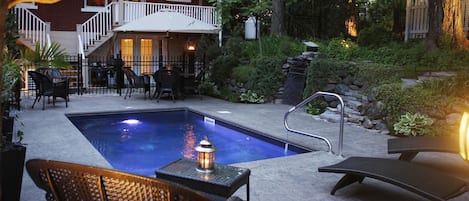Una piscina al aire libre, sillones reclinables de piscina