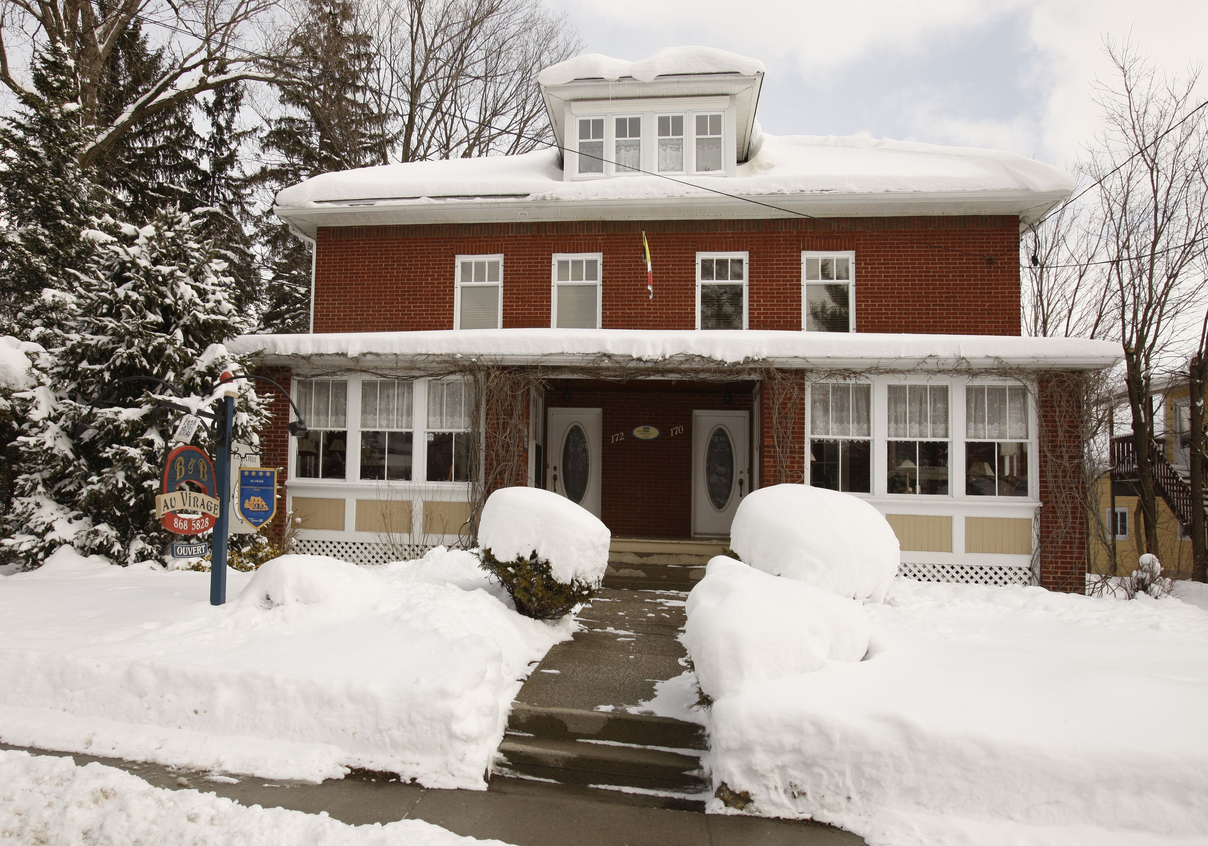 A two-story brick building with a snow-covered roof and a front entrance.
