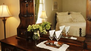A bedroom with a bed, a dresser, two lamps, a vase with flowers, and a mirror. - B&B Au Virage (Magog)