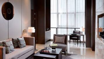 Um hall de hotel moderno com sofá, poltronas, mesa de centro e área de refeições.