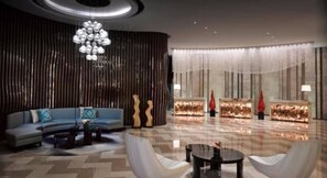 A spacious lobby with a curved sofa, a coffee table, and a decorative chandelier. - Melia Jinan (Jinan)