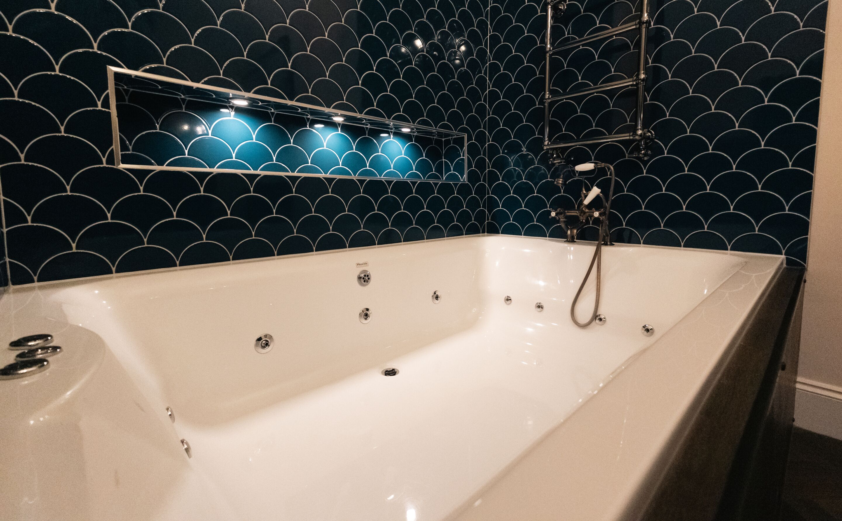 A modern bathroom with a freestanding bathtub, a wall-mounted mirror, and a showerhead.