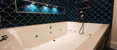A modern bathroom with a freestanding bathtub, a wall-mounted mirror, and a showerhead.