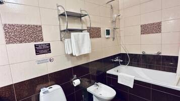 Un baño con inodoro, bidé y bañera.