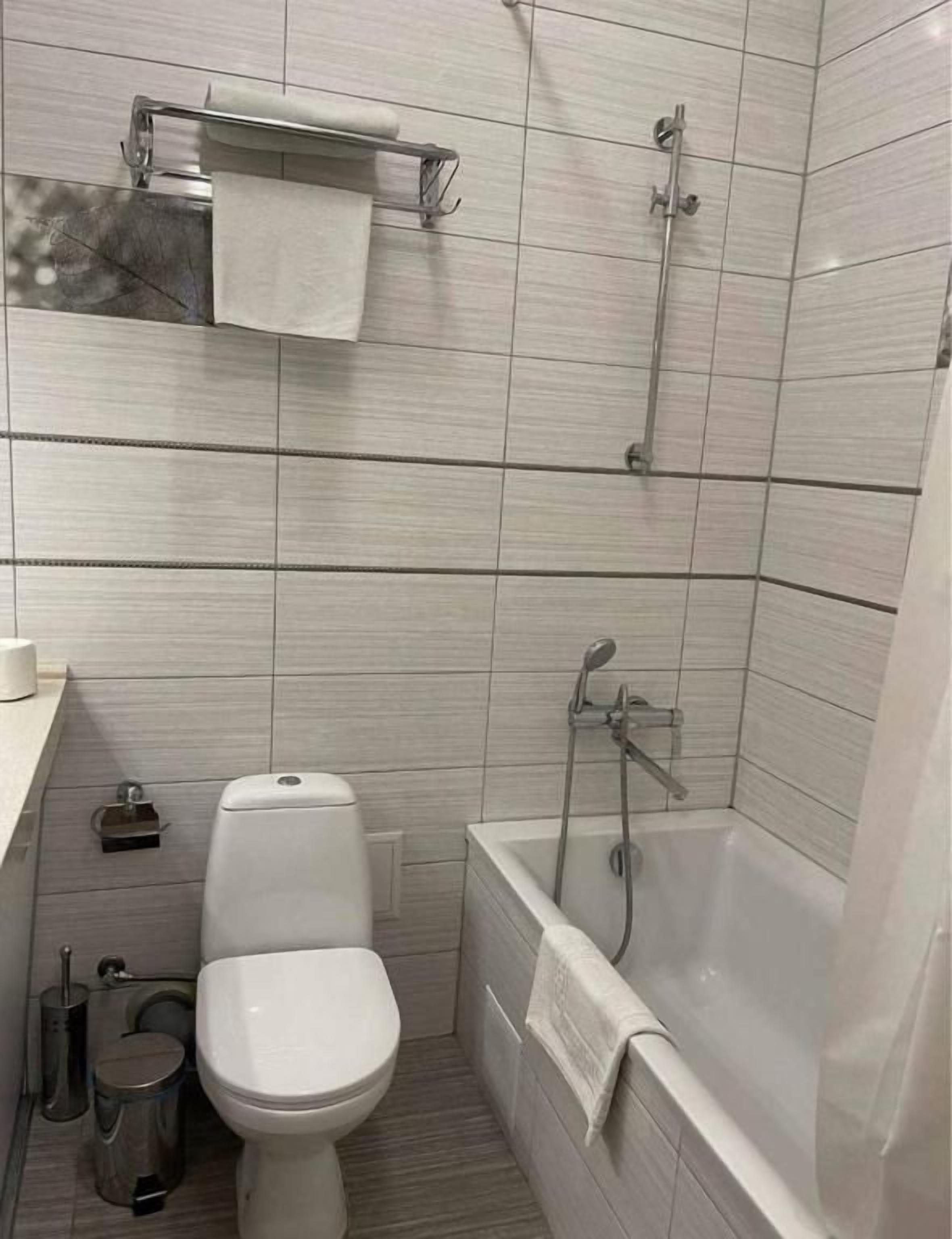 Une salle de bain avec des toilettes, un lavabo et une baignoire.