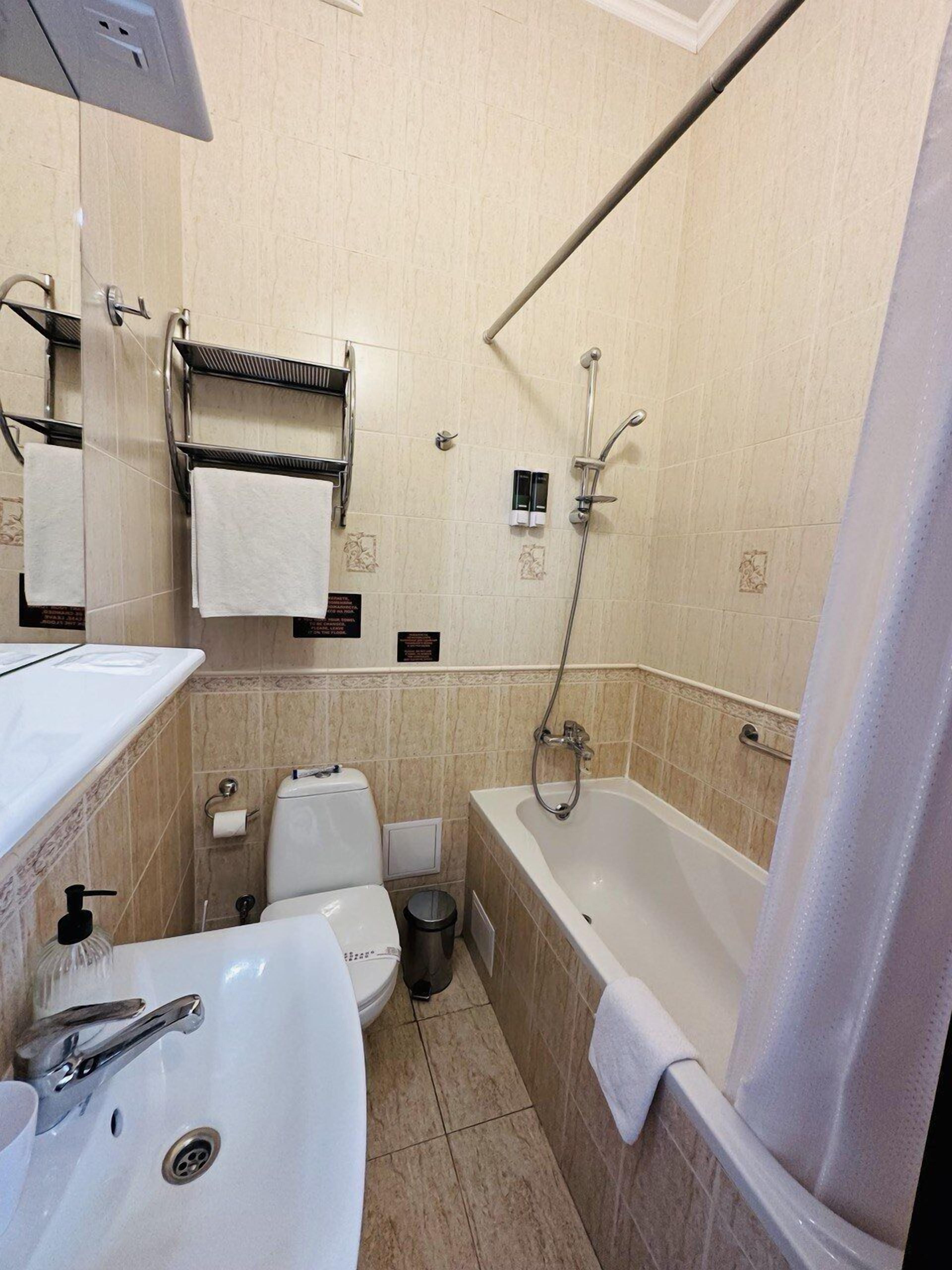 A bathroom with a sink, toilet, bathtub, and a towel rack.