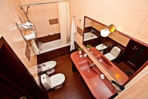 Bathroom features a bathtub, separate shower, and vanity with mirror.