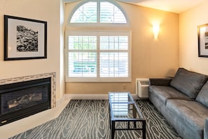 Cozy living space with a fireplace, sofa, and glass coffee table, offering a comfortable seating area.