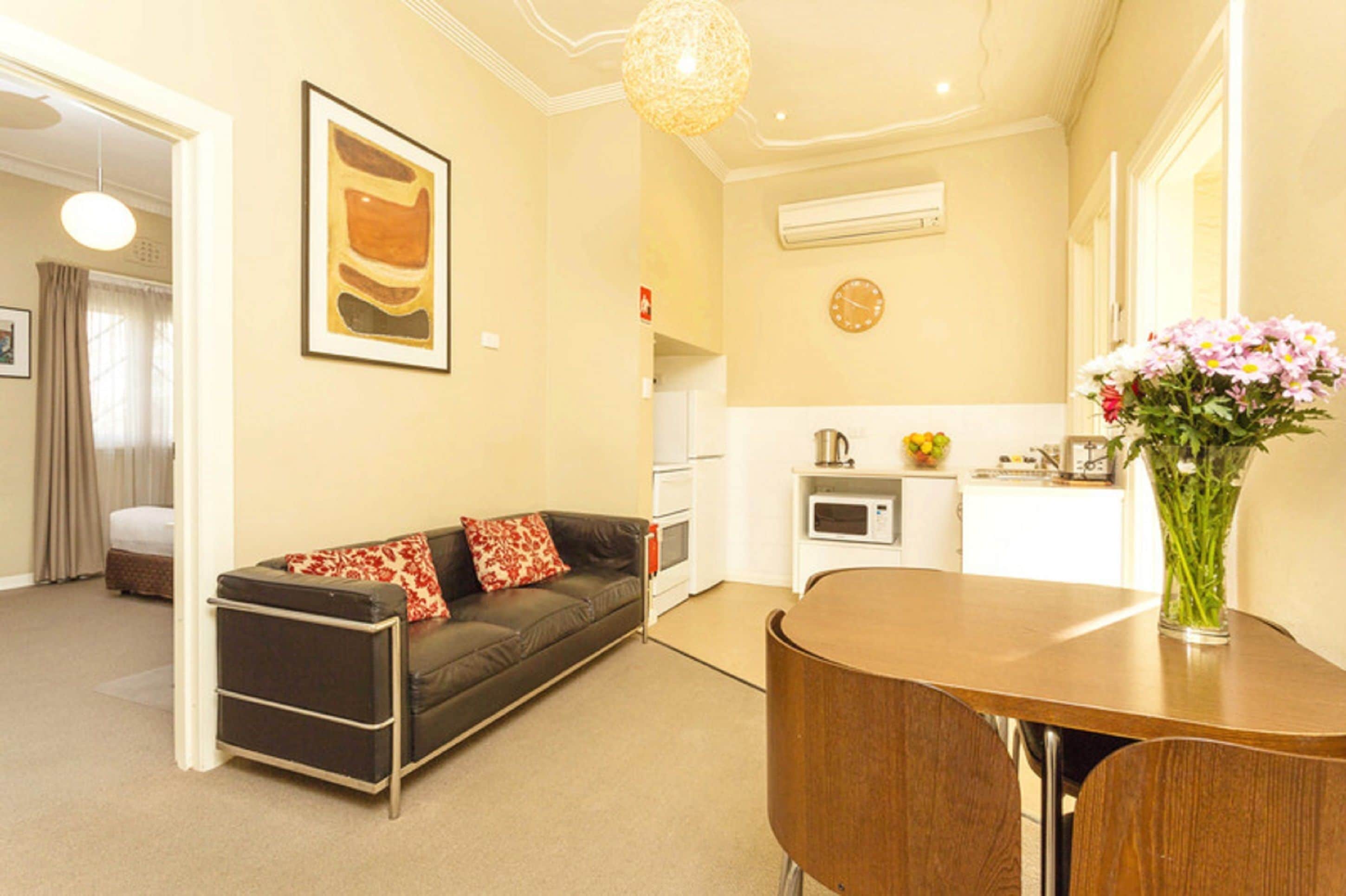 A compact living space with a sofa, a dining table, and a kitchen area.
