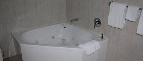 Une salle de bain moderne avec une baignoire sur pieds, des toilettes et un porte-serviettes avec deux serviettes.