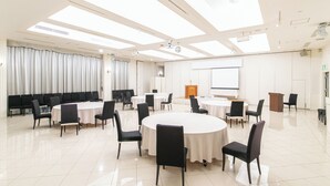 A conference room with a large oval table, multiple smaller tables, and rows of chairs. - Hotel Verfort Hyuga (Hyuga)