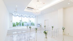 A spacious room with clear chairs arranged in rows, a chandelier, and large windows with a view. - Hotel Verfort Hyuga (Hyuga)