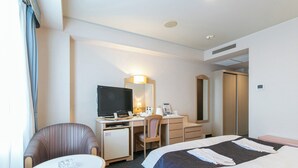A hotel room with a bed, a desk with a computer, a chair, a small table, and a television. - Hotel Verfort Hyuga (Hyuga)