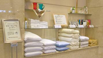 A hotel display with neatly stacked pillows and a framed signboard.