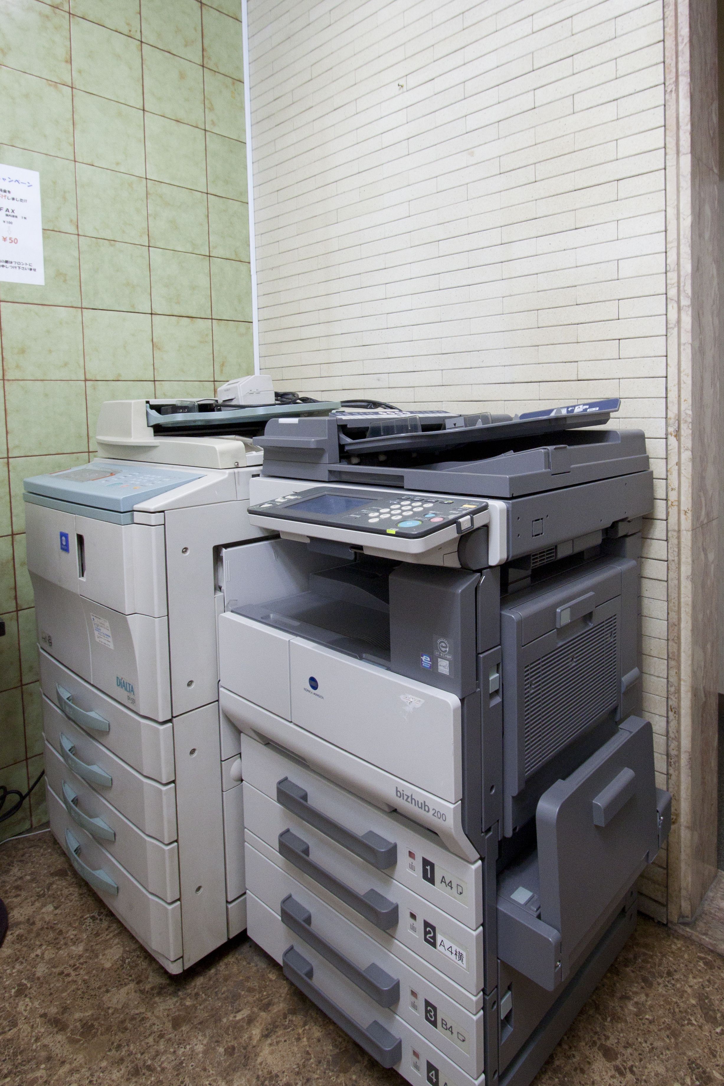 A row of stacked printers in an office setting.