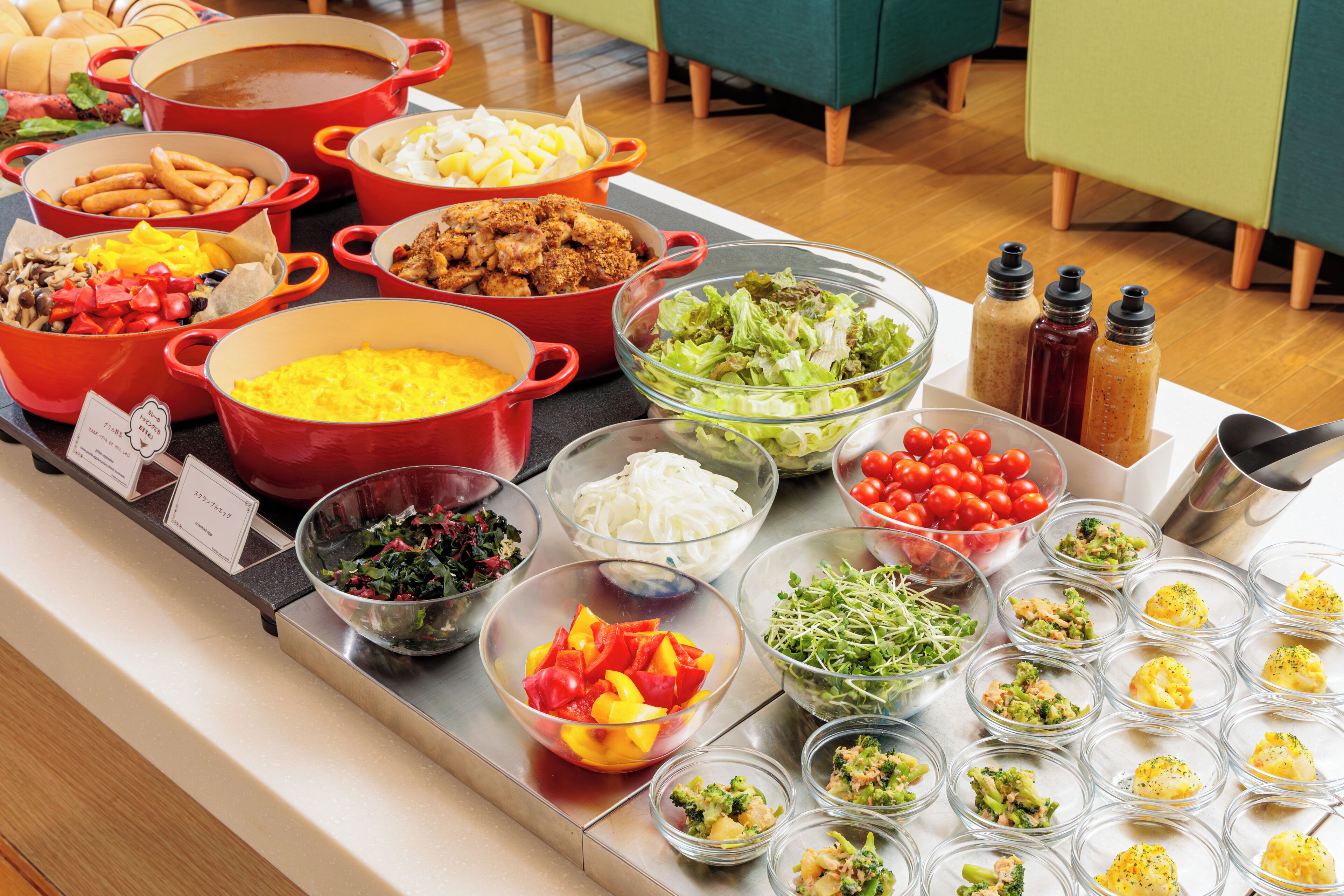 A buffet table with various dishes including salads, vegetables, and cooked meats.