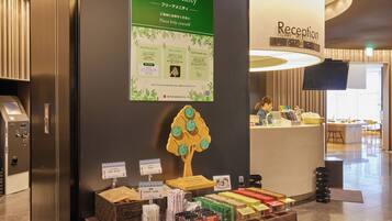 A reception area with a sign for free amenities, a reception desk, and a display of various products.