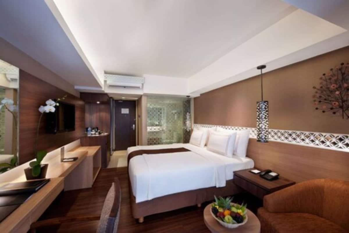 Una habitación de hotel moderna con una cama grande, un escritorio y un área de estar.
