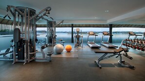 Ein Fitnessstudio mit unterschiedlichen Trainingsgeräten, einer großen Trainingskugel und Kurzhanteln.