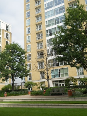 A multi-story residential building with a yellow facade, large windows, and balconies.