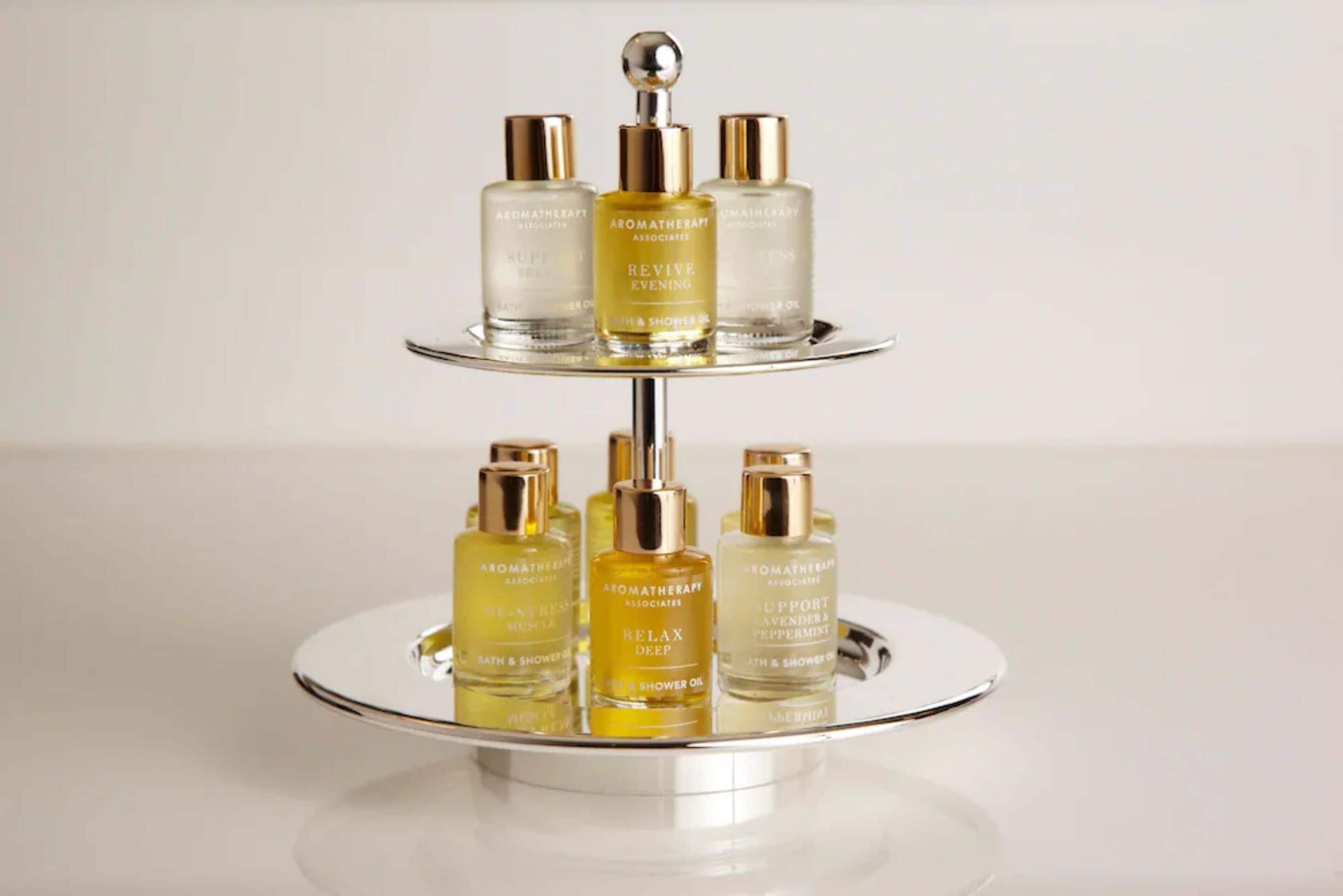 A three-tiered display stand with various bottles of aromatherapy products.