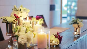 Una mesa con velas y arreglos florales.