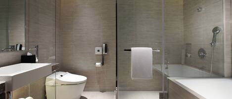 A modern bathroom with a glass-enclosed shower, a white bathtub, and a toilet.
