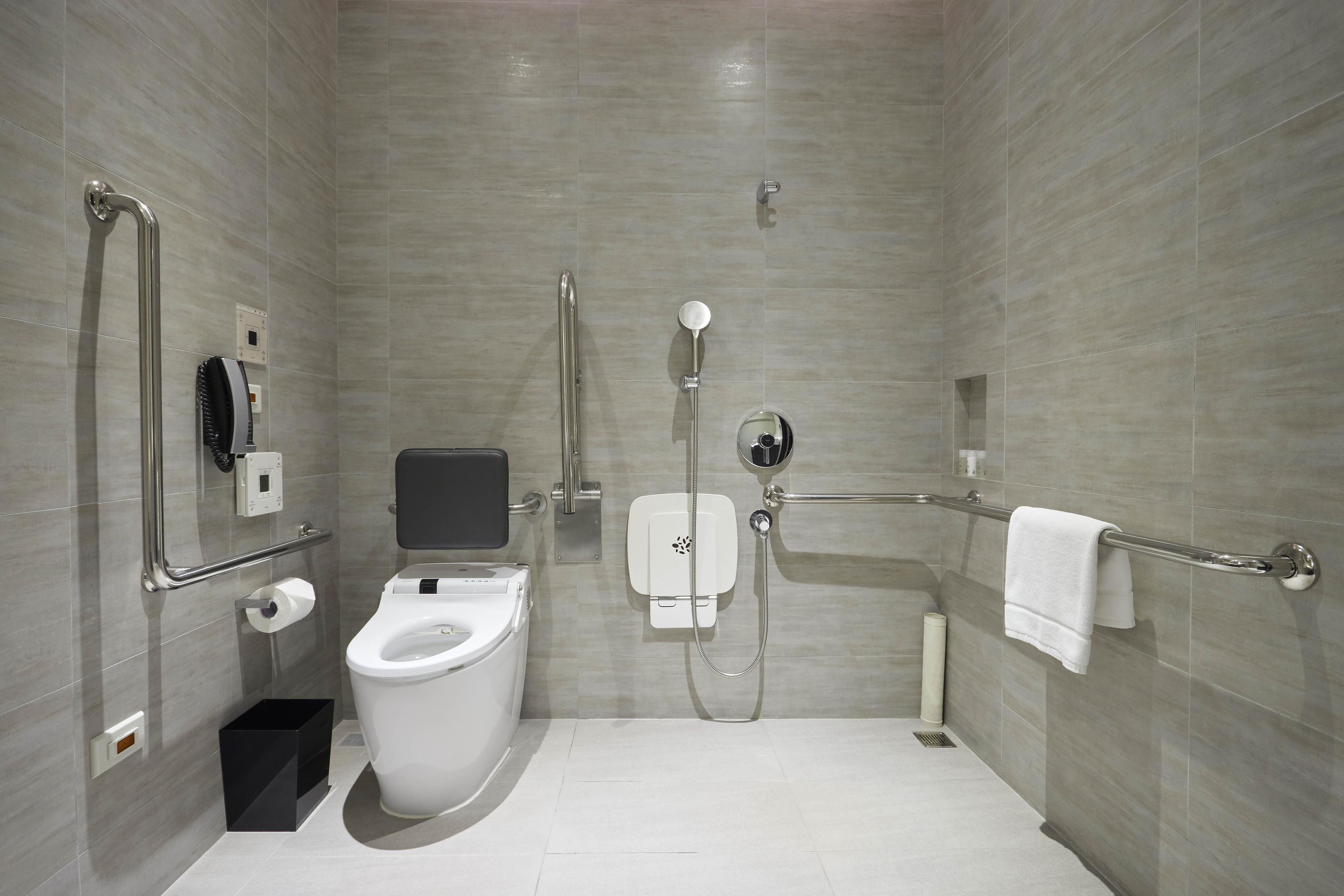 Een moderne badkamer met toilet, douche en handdroger.