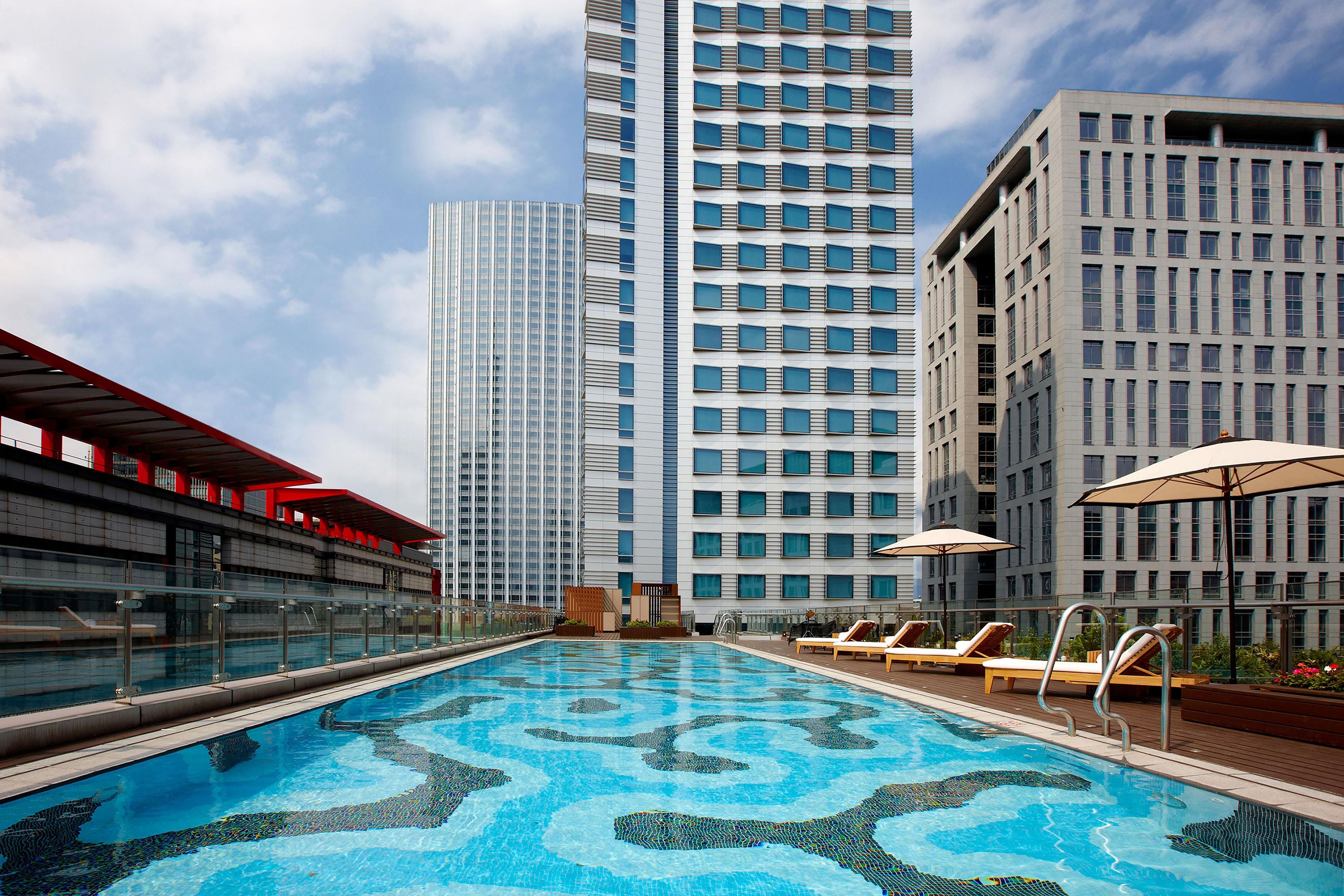A rooftop pool with a clear view of tall buildings in the background.