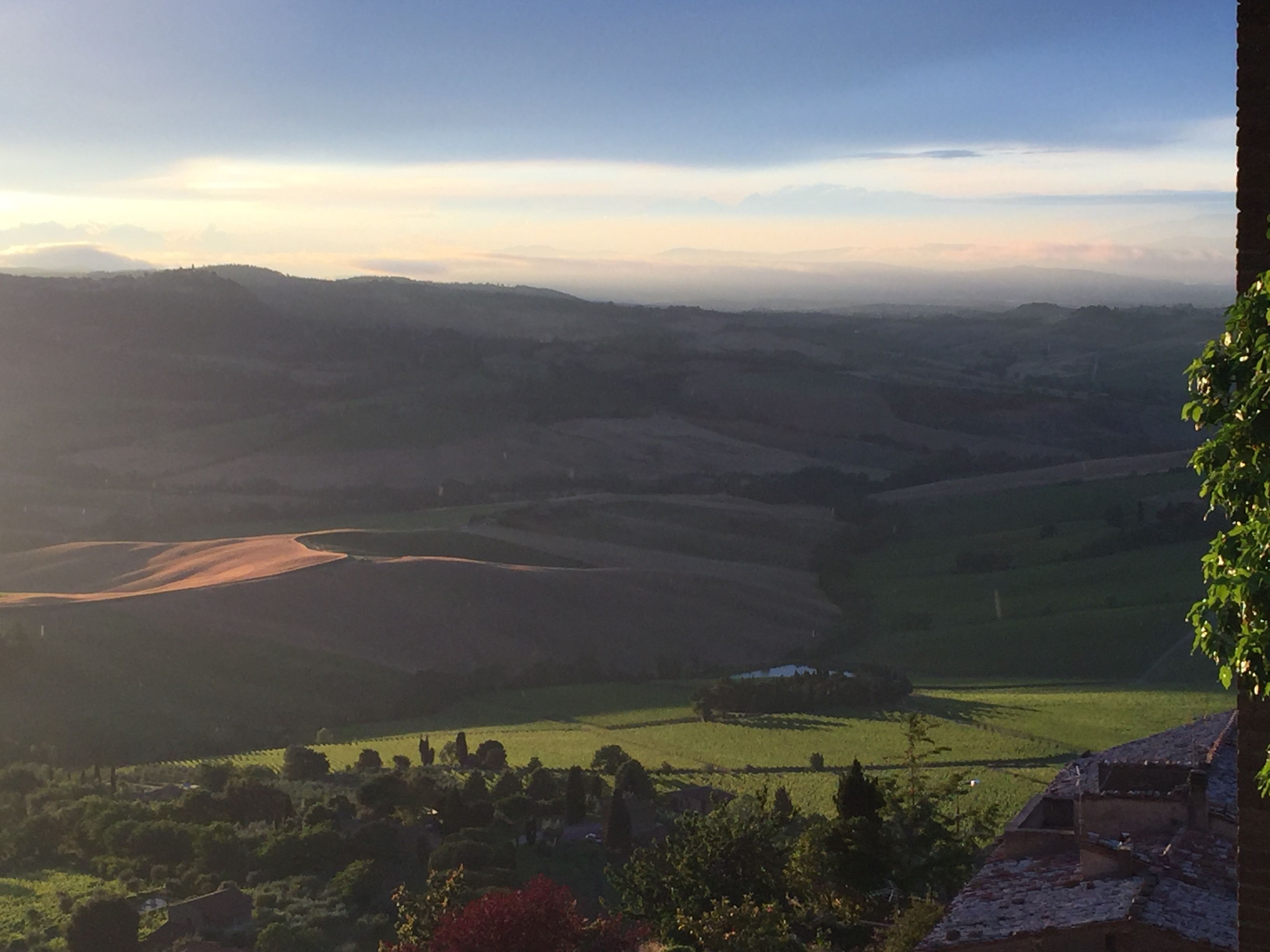 A panoramic view of rolling hills and a distant village.