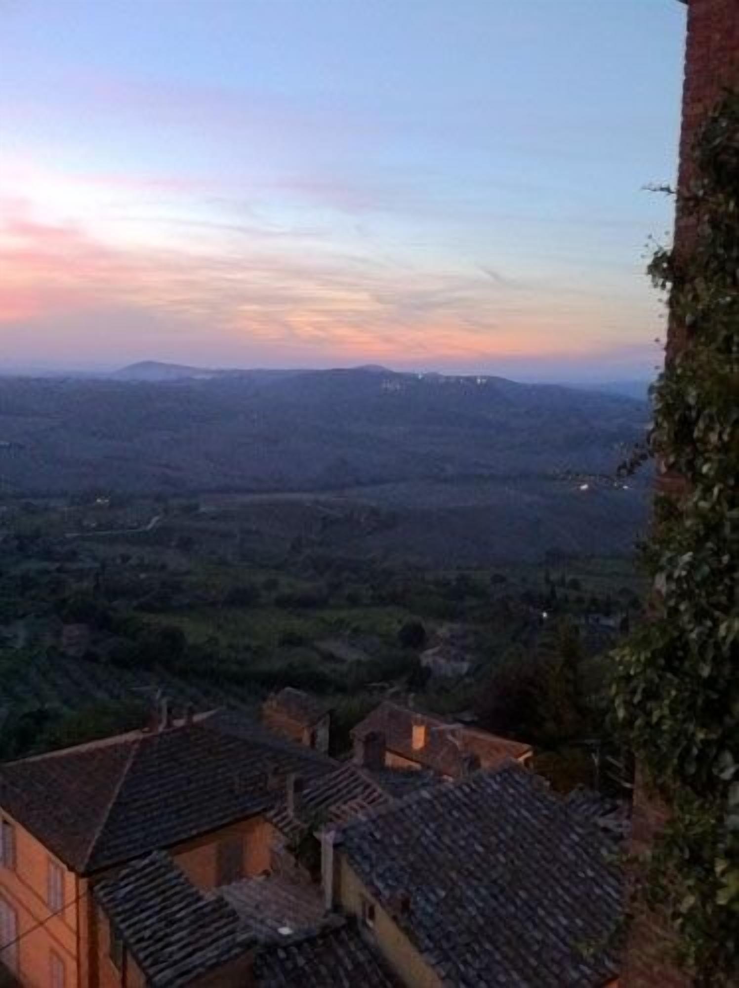 A view of a valley with houses and a distant mountain range.