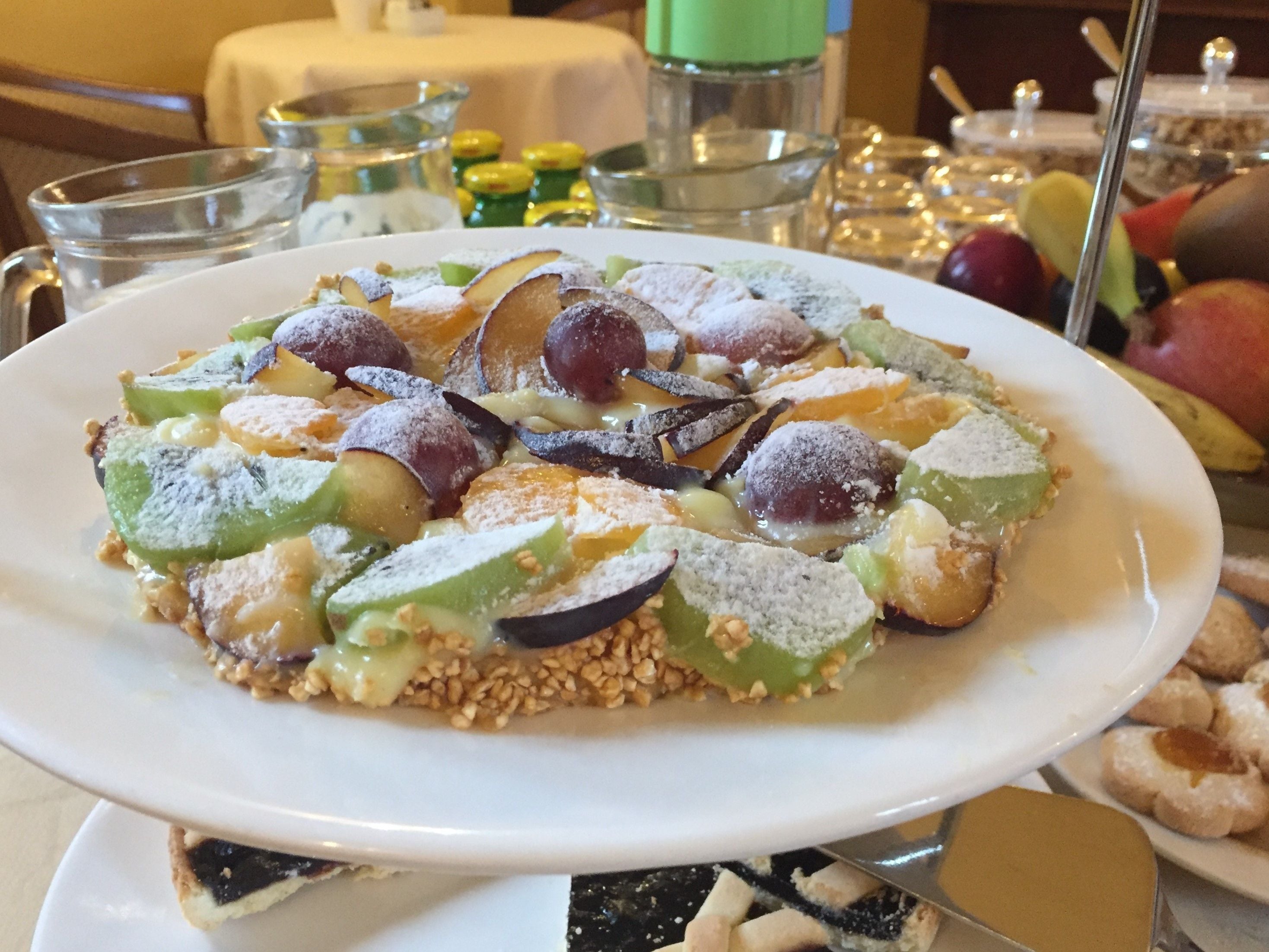 A dessert plate with various fruits and nuts on a white plate.