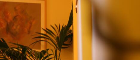 A staircase with a handrail, a framed artwork on the wall, and a potted plant.