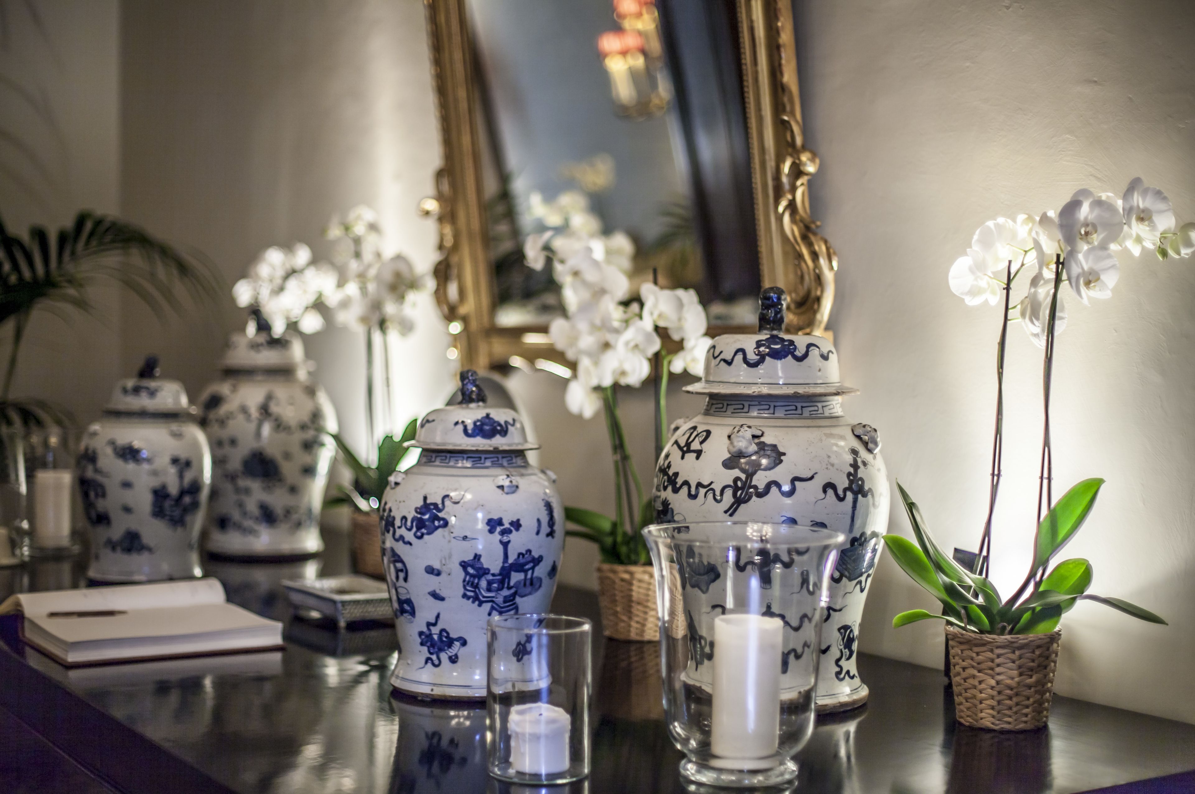 A table with decorative vases, a candle, and a potted plant.