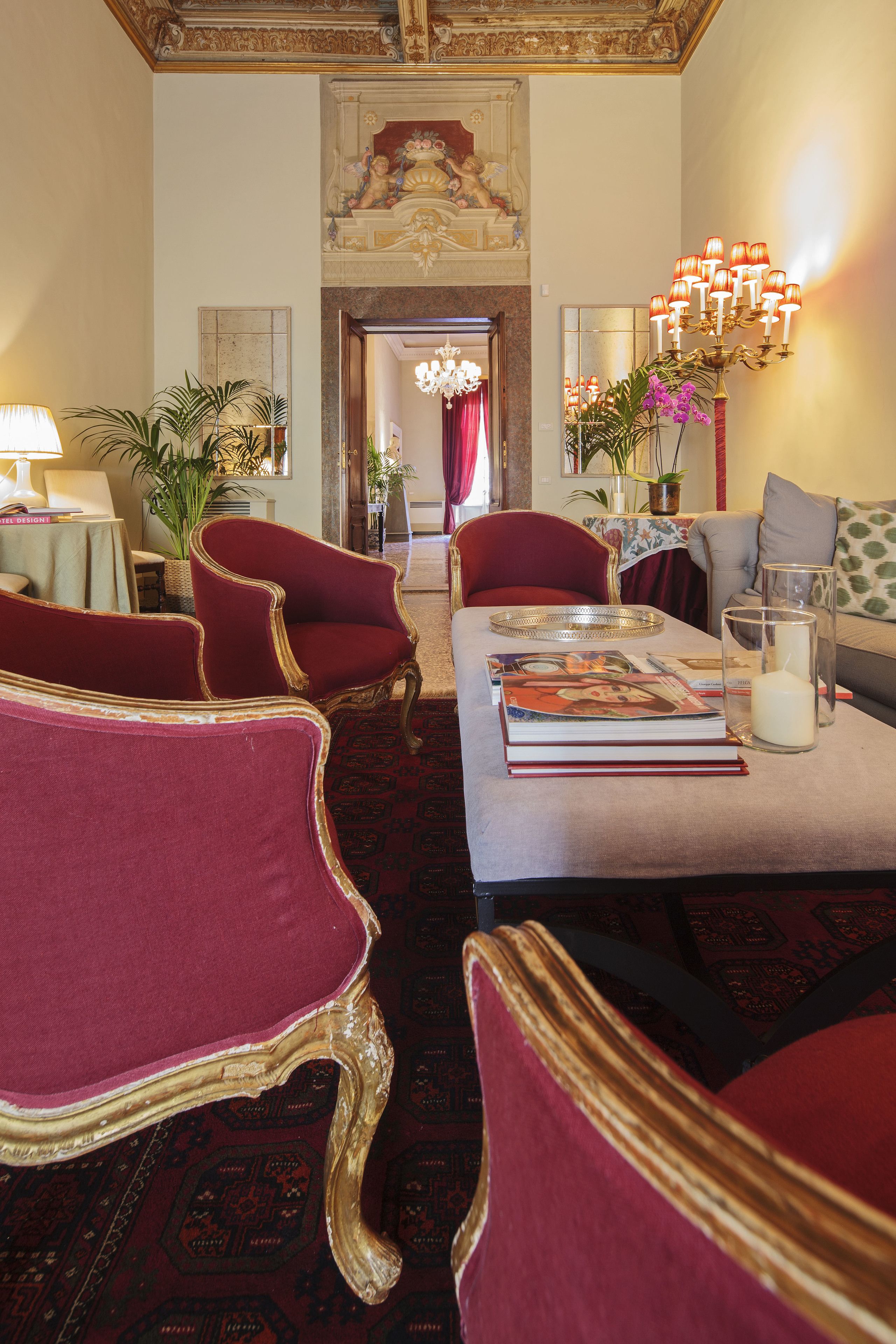 A grand room with ornate furniture, a chandelier, and a fireplace.